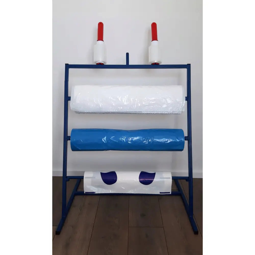 Beskyttelsesfolie for verksted, metallstativ med tre plastfolieruller og to hvite håndtak med røde topper.