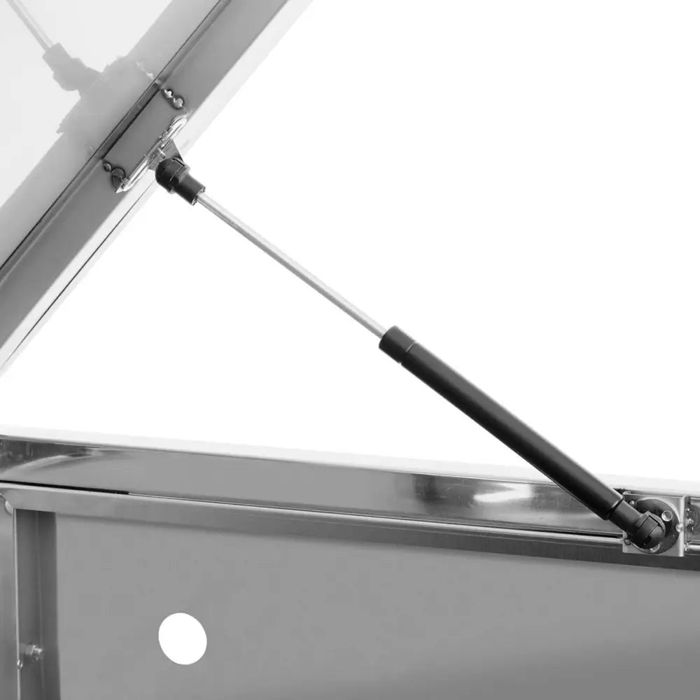 Gassfjær i svart og metall festet til delvis åpent lokk i rustfritt stål på avfallsbeholderhus.