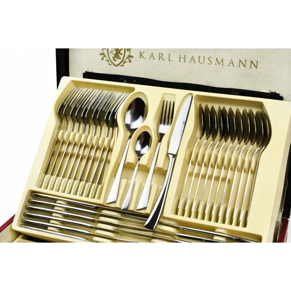 Bestikksett for 12 personer i rustfritt stål, oversiktsbilde av gafler, kniver og skjeer i kremfarget innsats.