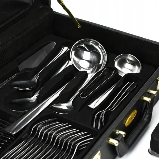 Bestikksett i rustfritt stål, oversiktsbilde av alle deler organisert i sort koffert med gulldetaljer.