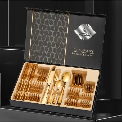 Bestikksett i gull for seks personer, oversiktsbilde av alle 24 deler i åpen sort eske med bikubemønster.