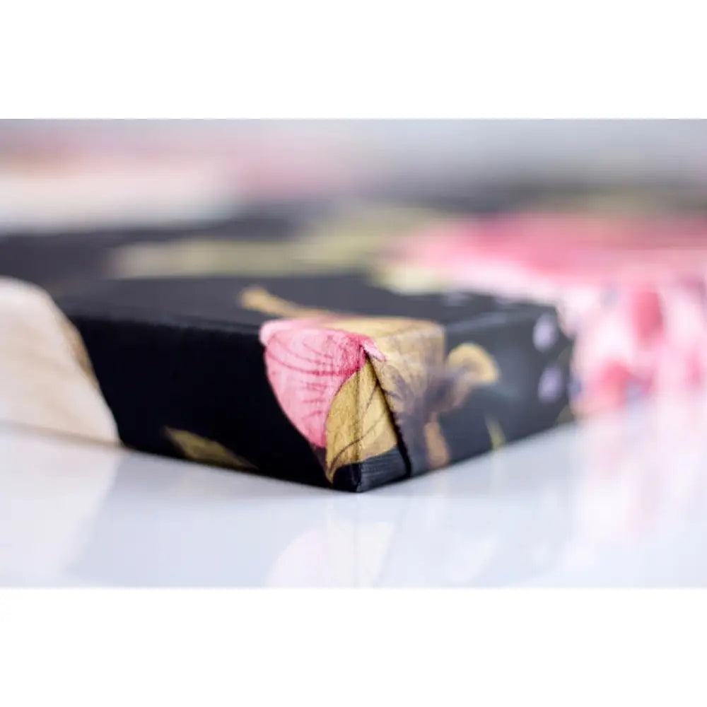 Lerretsbilde til barnerom, nærbilde av sort hjørne med rosa og grønne blomster, viser tekstur og kant.