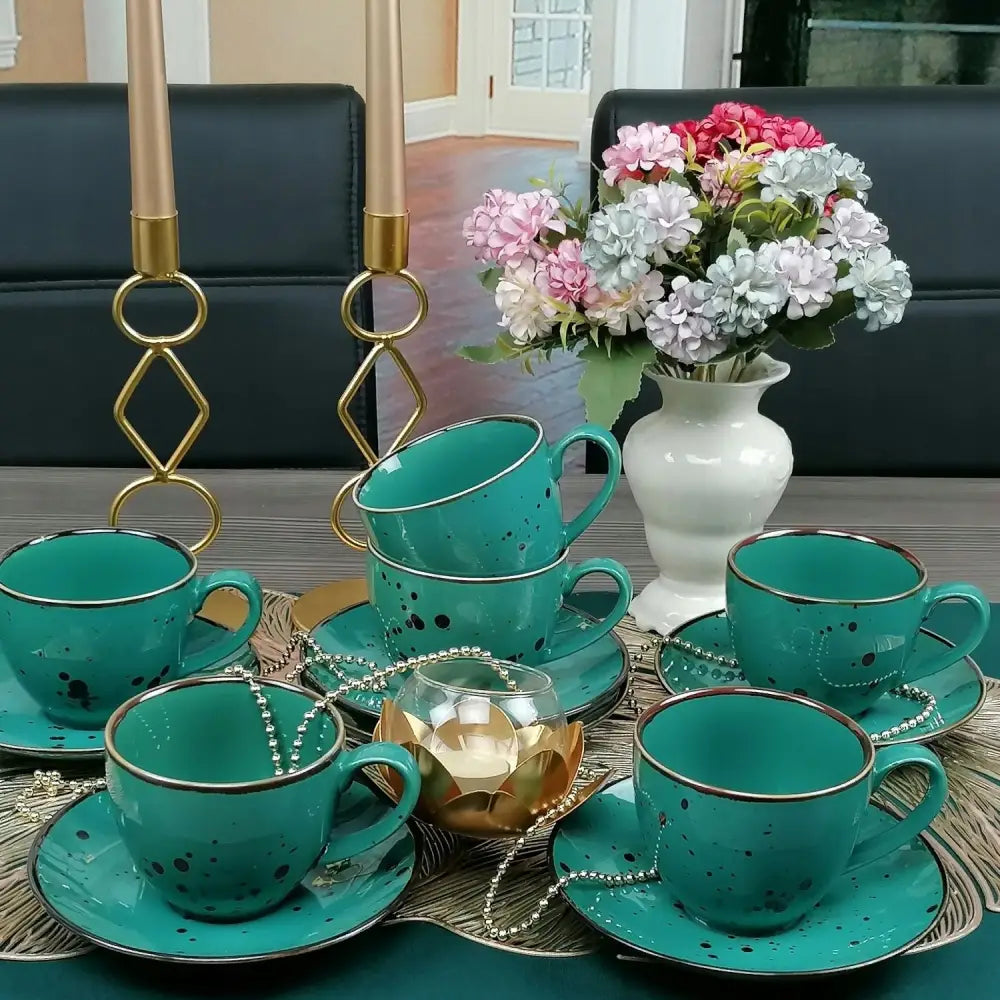 Bogucice Cottage Turkis koppesett, seks grønne kopper med gullkant og prikker, pyntet bord med blomster.