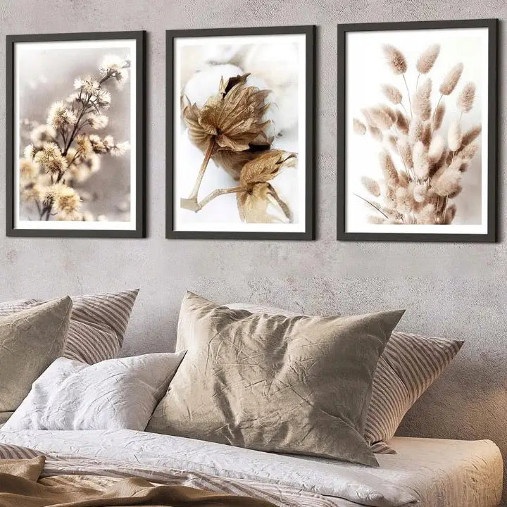 Boho blomster tryptyk, tre naturbilder i beige toner hengt over seng med lyse puter og nøytralt sengetøy.
