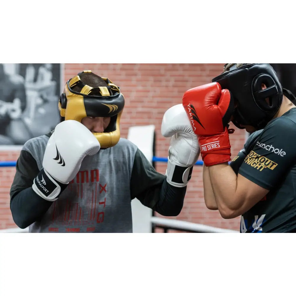 To boksere i sparring, fokus på hvite boksehansker CRAB i ekte skinn og gull/svart hjelm.