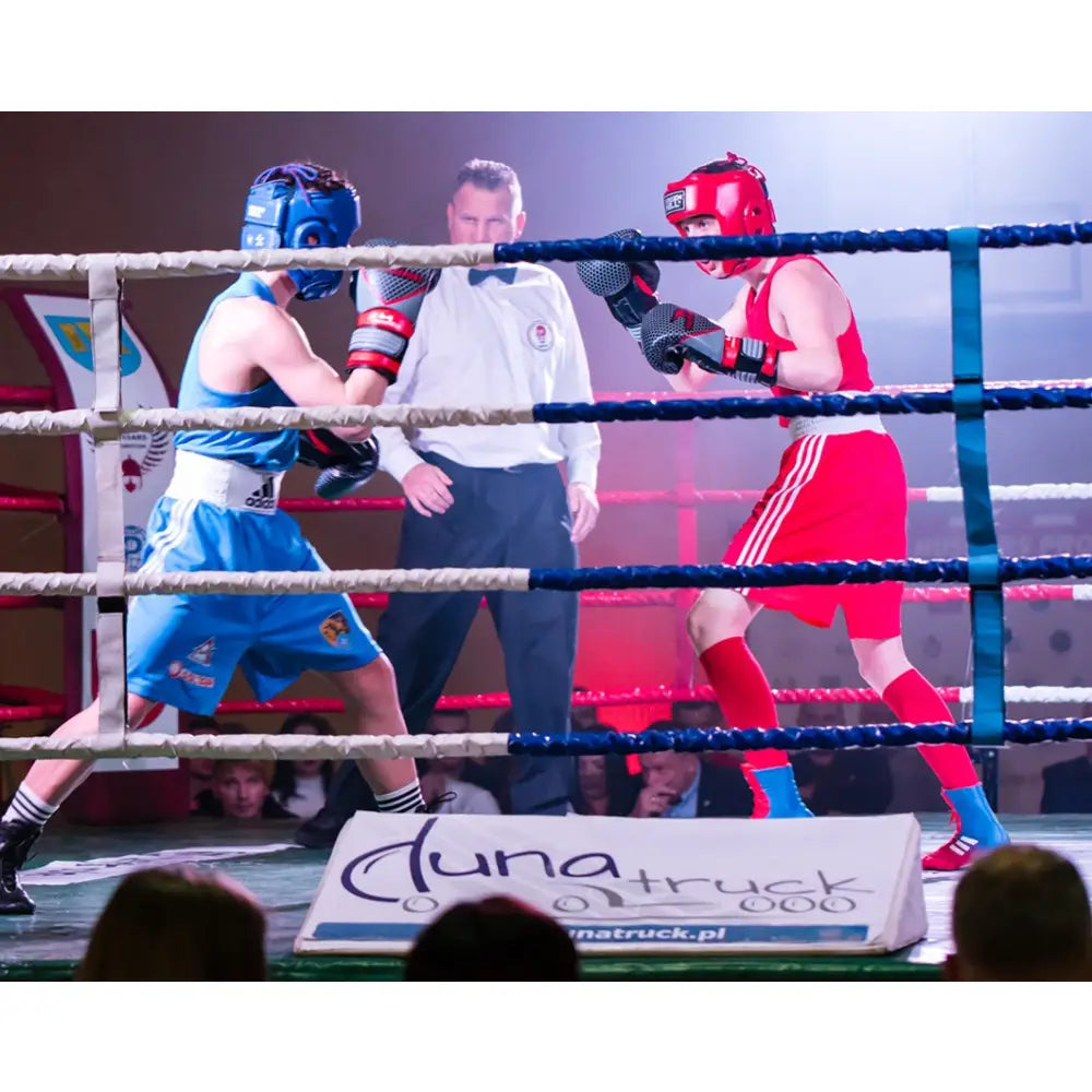 Boksehansker Naturlig Skinn PRO SPIDER 14 oz brukt i kamp, blå utøver slår mot rød motstander i boksering.