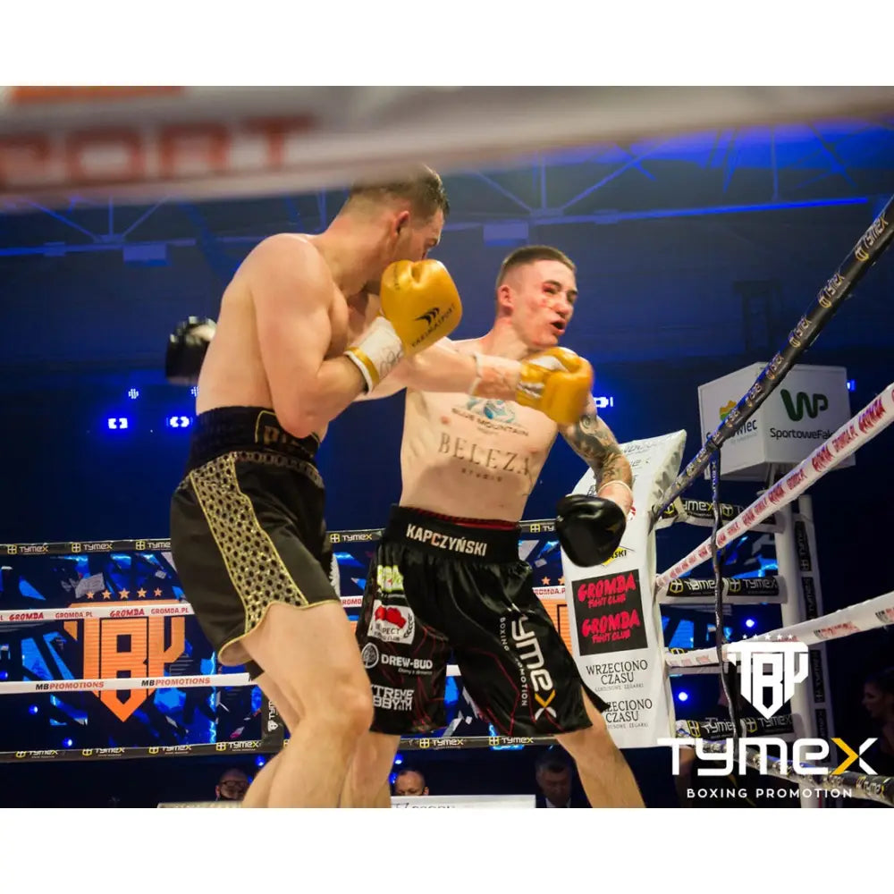 Boksehansker TIGER GOLD L 8 oz i bruk under kamp, fokus på gul og svart hanske med leopardmønster i ringen.