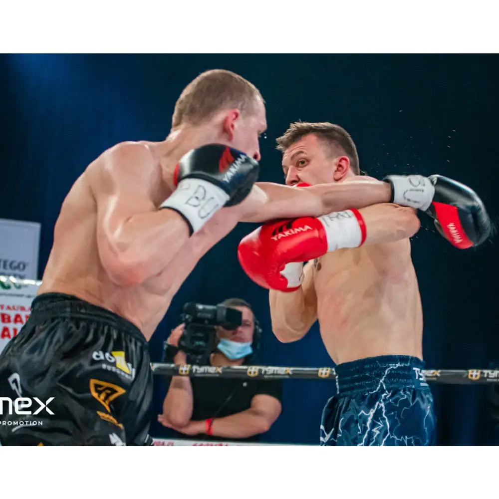 To boksere i kamp, iført VARG røde boksehansker, intense bevegelser midt i bokseringen.