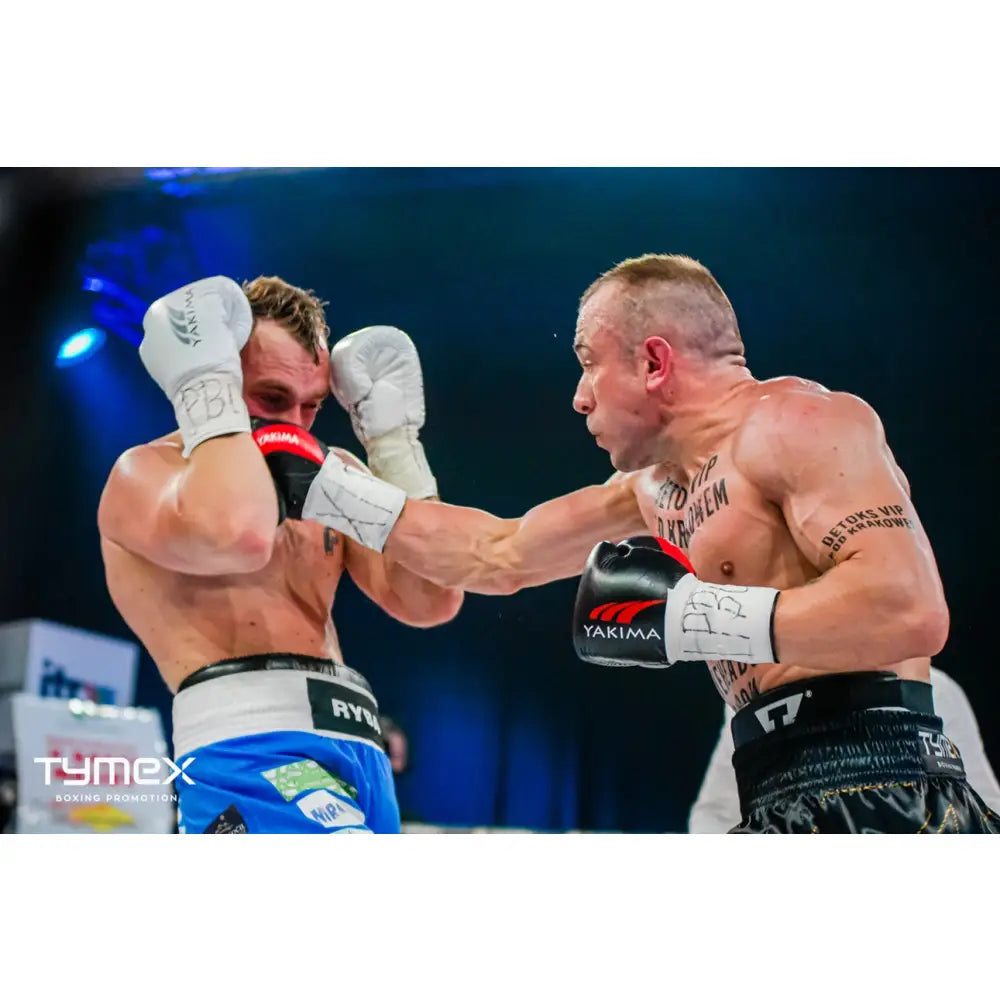 Boksehansker VARG svart, nærbilde av to boksere i kamp der én treffer med kraftig høyre, fokus på hanskene.