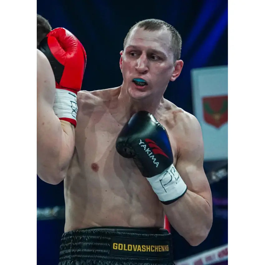 Boksehansker WOLF BLACK V 10 oz brukt av bokser i ringen, fokus på svarte hansker under kamp.