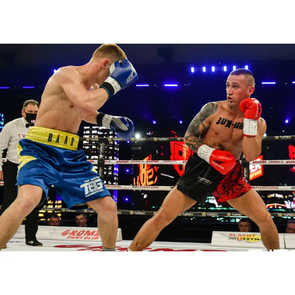 Boksehansker WOLF BLUE V 10 oz, i bruk under boksekamp mellom blå og rød utøver i opplyst boksering.