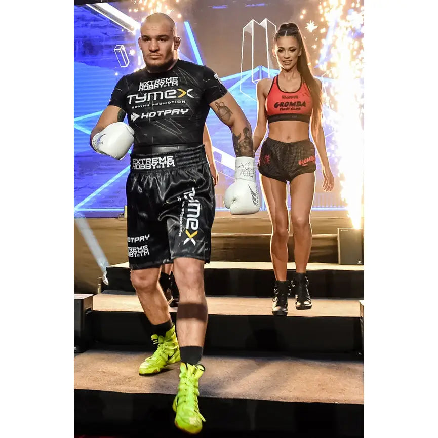 Boksehansker WOLF HVIT, brukt av bokser i svart antrekk på trapp med lyseffekter og gnister.