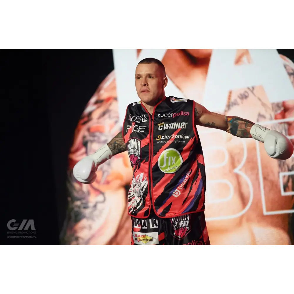 Boksehansker WOLF WHITE, hvit modell i bruk av mann med rød-sort garderobe, armer utstrakt foran bakgrunn.