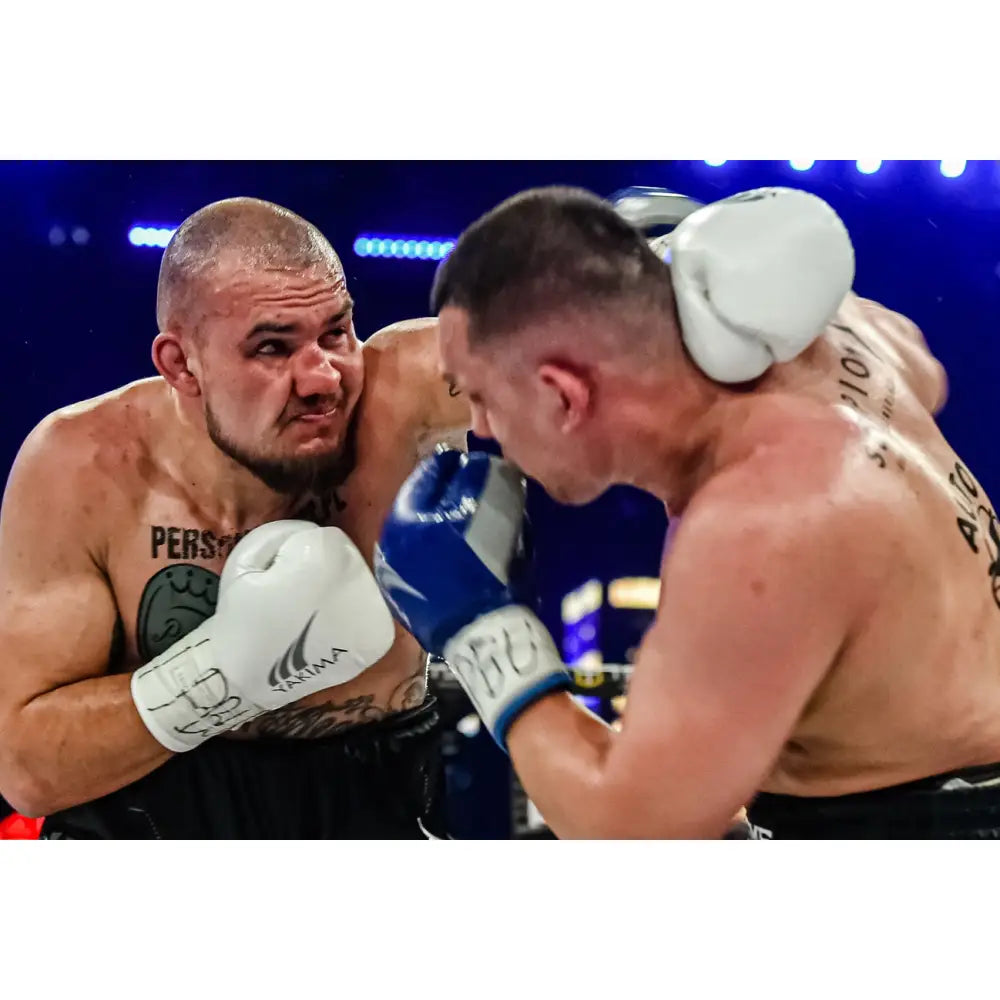 Boksehansker WOLF WHITE 14 oz, nærbilde av slag i kamp med hvite hansker mot blå bak blått lys.