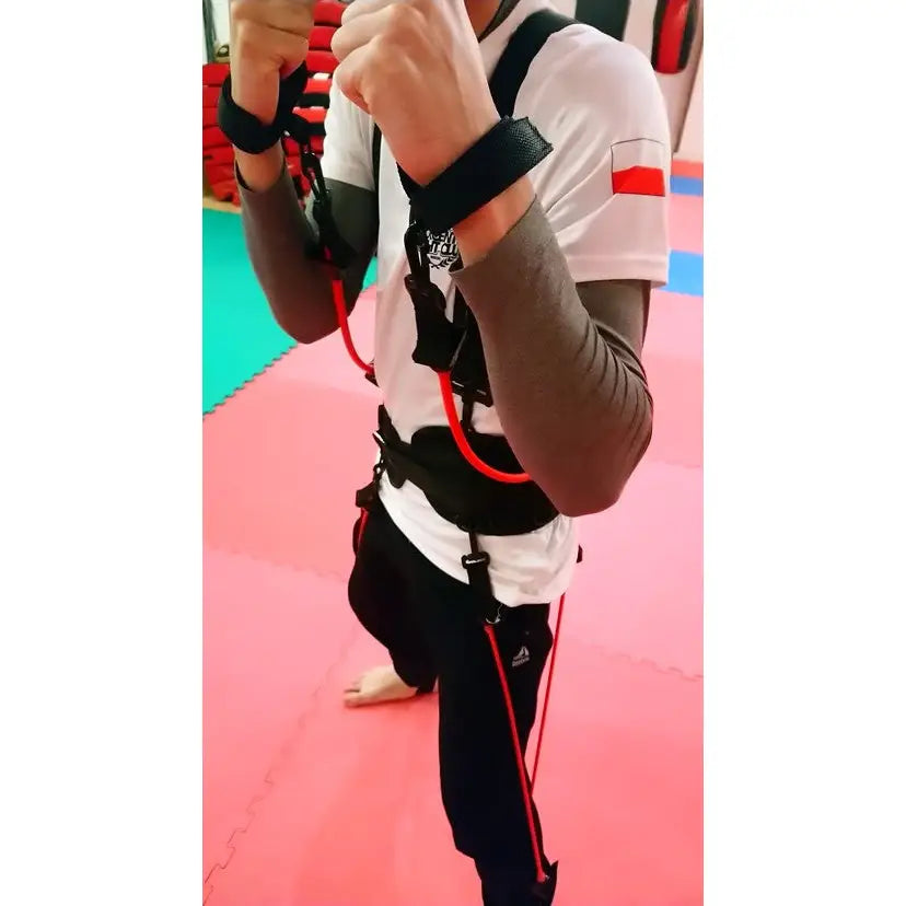 Boksetrening Kaugummi, sidevisning av utøver med strikkfester i bokseposisjon på rød treningsmatte.