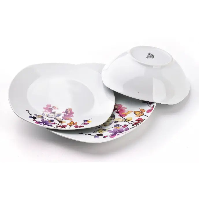 Botanisk lilla middagsservise, to porselensskåler med fargerik blomsterdekor, én vist opp-ned.