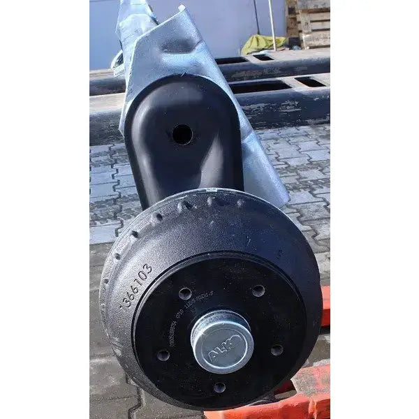 Aksling tilhenger AL-KO, frontvisning av sort bremsetrommel med synlige bolter og nummermerking på brostein.