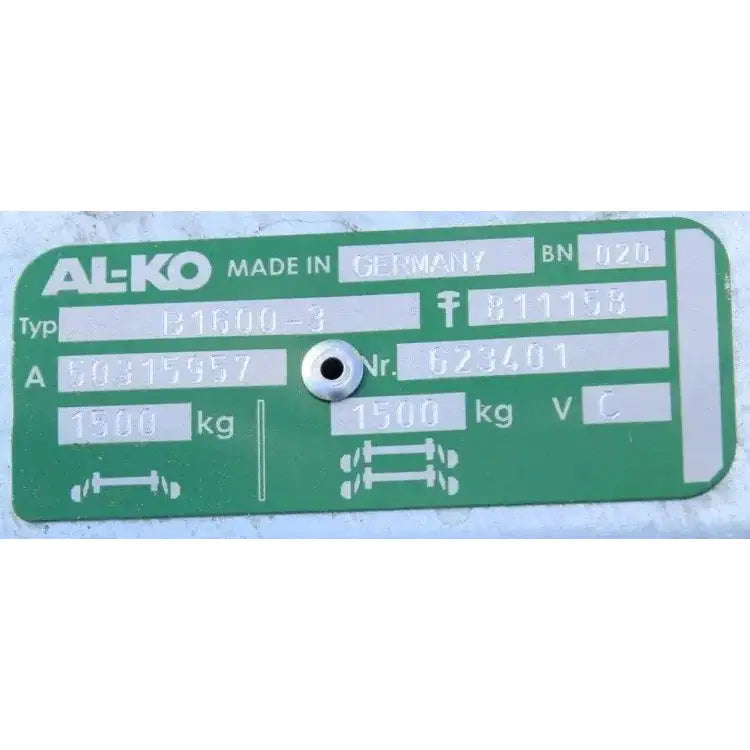 Aksling tilhenger AL-KO, nærbilde av grønn og sølvfarget metallplate med preget teknisk informasjon.