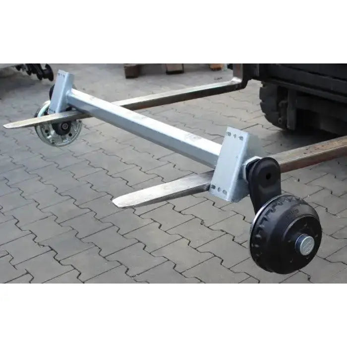 Aksling tilhenger AL-KO 1200mm, stålramme med hjulaksler på truckgafler, skrå sidevisning.