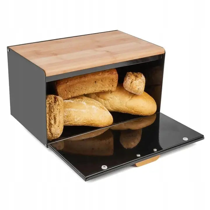 Sort brødboks med trelokk, frontlokk åpent og assorterte brød synlige inni, sett skrått forfra.