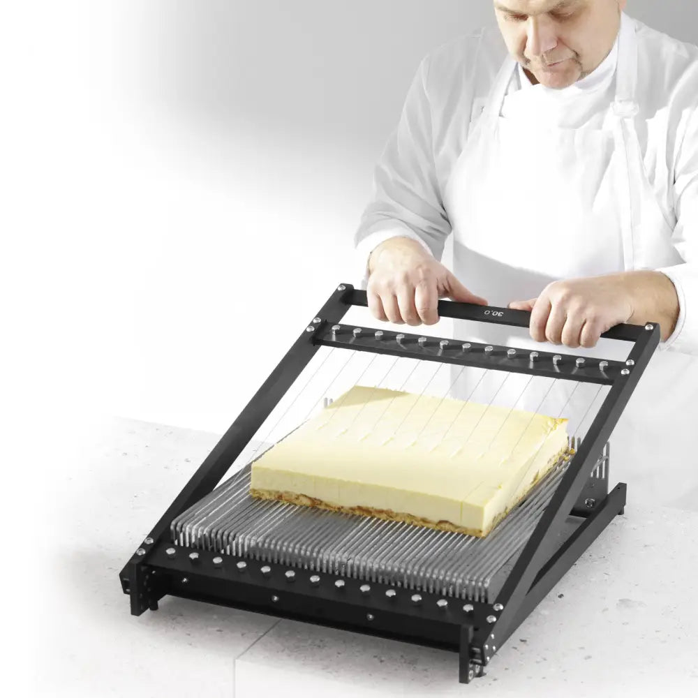 Cakery Guitar Dough Divider med tre rammer, i bruk for å skjære kake jevnt med parallelle ståltråder.