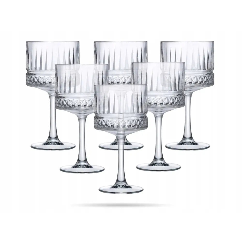 Cocktailglass Elysia, seks glass med utskårne geometriske mønstre, brede kanter og solide stilker mot hvit bakgrunn.