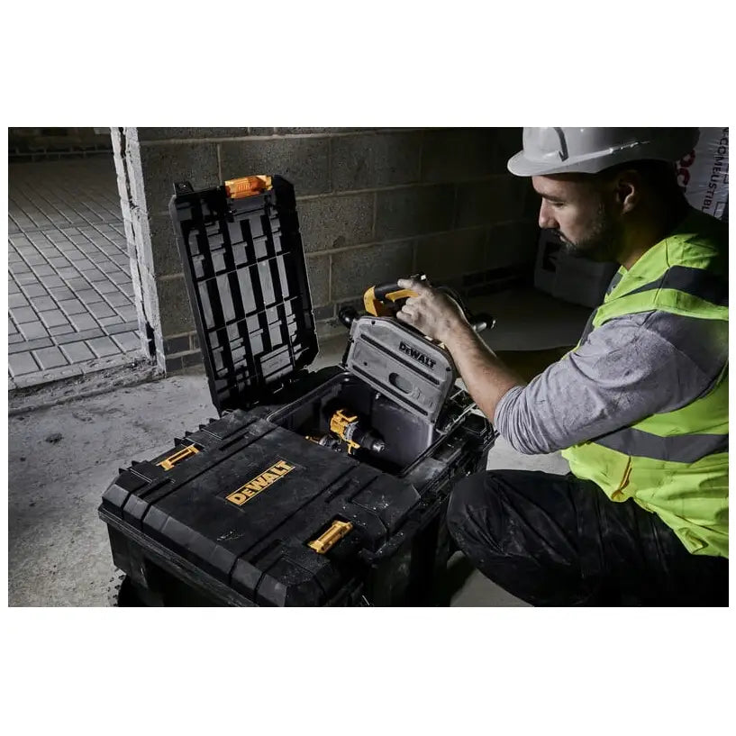 Dewalt Tstak koffert med to skuffer og hjul, åpen med elektroverktøy i bruk på industrigulv.