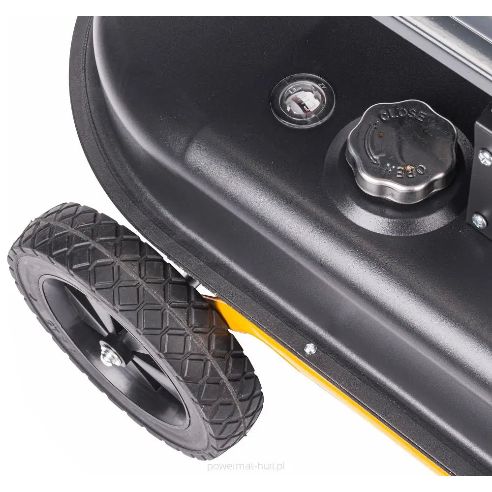 Dieselvarmer, detalj av svart plastlokk med åpen/lukk-symbol, grovmønstrede hjul og synlig måler på metallchassis.