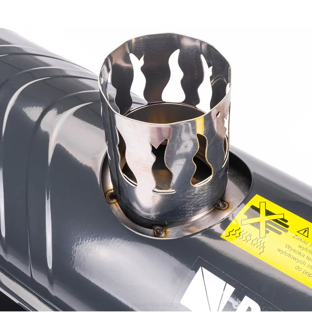 Dieselvarmer, nærbilde av perforert stålgitter og metallrør på sort overflate med gul advarselsetikett.