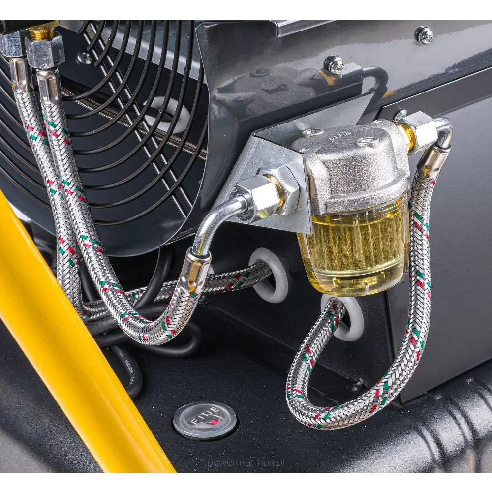 Dieselvarmer, nærbilde av filterenhet i metall og glass med fargede stålslanger i industrielt miljø.