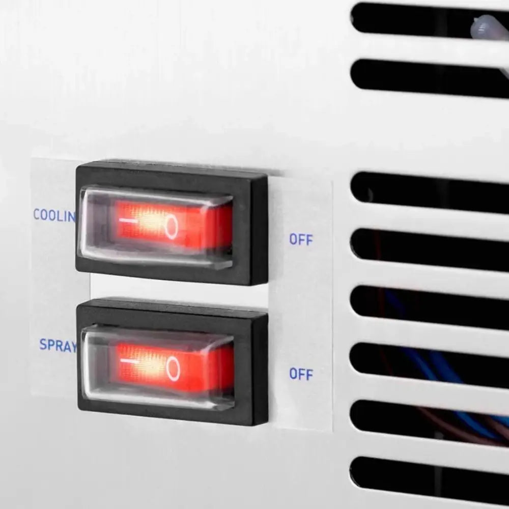 Dispenser kjøler, nærbilde av to røde av/på-brytere på hvitt panel med ventilasjonsåpninger til høyre.
