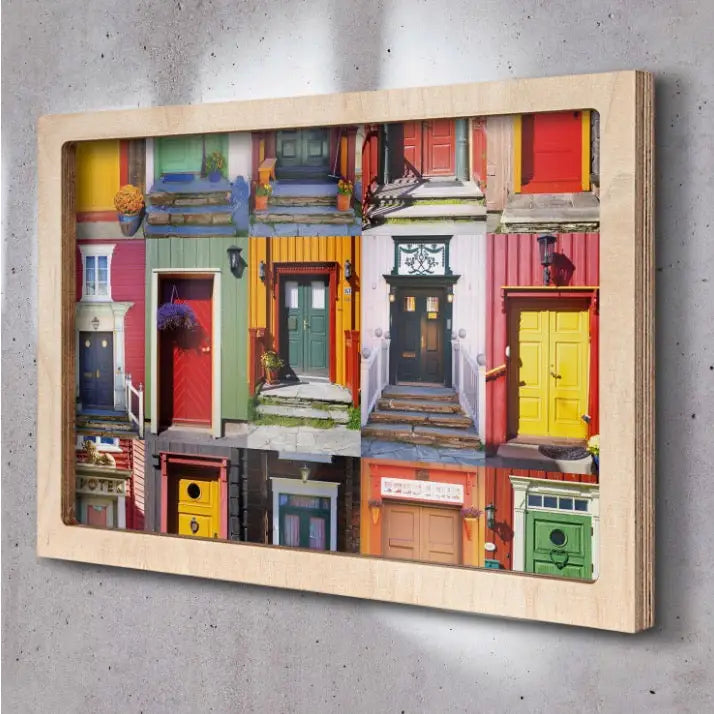 Fargerik collage av norske dører i lys treramme, fotografert skrått mot grå vegg, ulike farger og stiler.