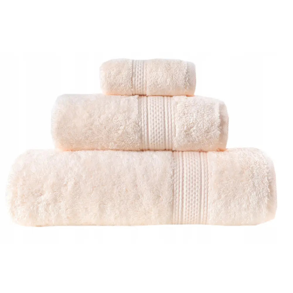 Egyptisk håndkle i kremfarget frotté, tre ruller med dekorbånd tydelig synlig på midten.