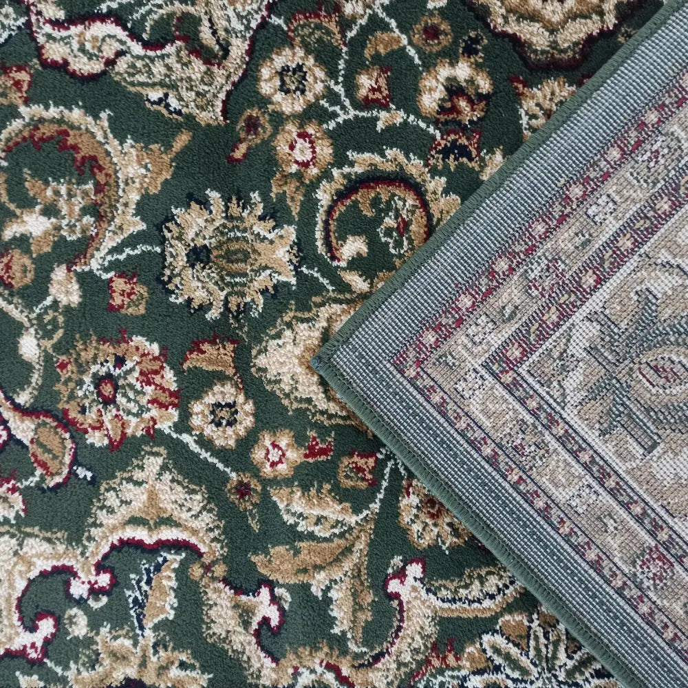 Detaljbilde av eksklusivt grønt teppe, hjørne med synlig kant, baksiden og orientalske mønstre.