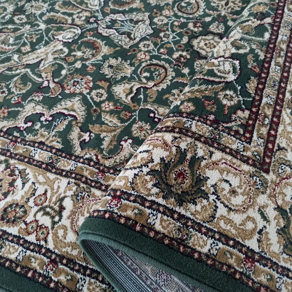 Eksklusiv grønn teppe 200 x 300 cm med orientalsk mønster, nærbilde av hjørne brettet opp for å vise tykkelse.