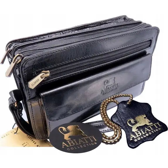 Eksklusiv sort håndsatchel i glatt skinn med preget Abiatti-logo, synlige glidelåslommer og gyllent anheng.