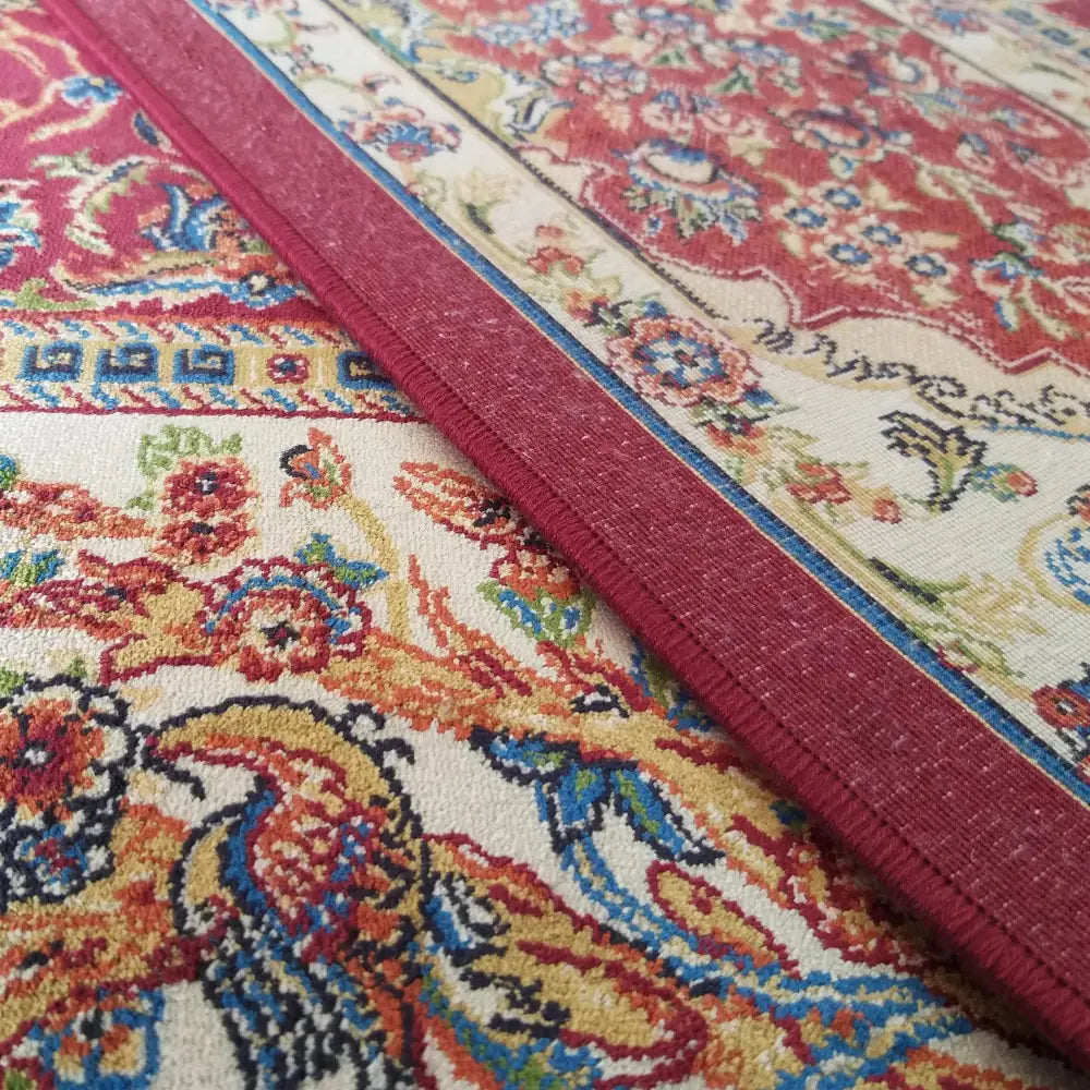 Eksklusiv Qum Silk Tepe 11, nærbilde av rødt orientalsk teppe med blå og beige detaljerte motiver.