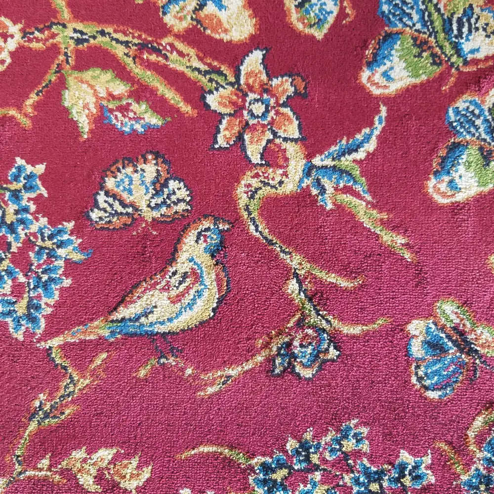 Eksklusiv Qum Silk Tepe 11, detaljert nærbilde av burgunderrødt teppe med broderte fugler og blomster.