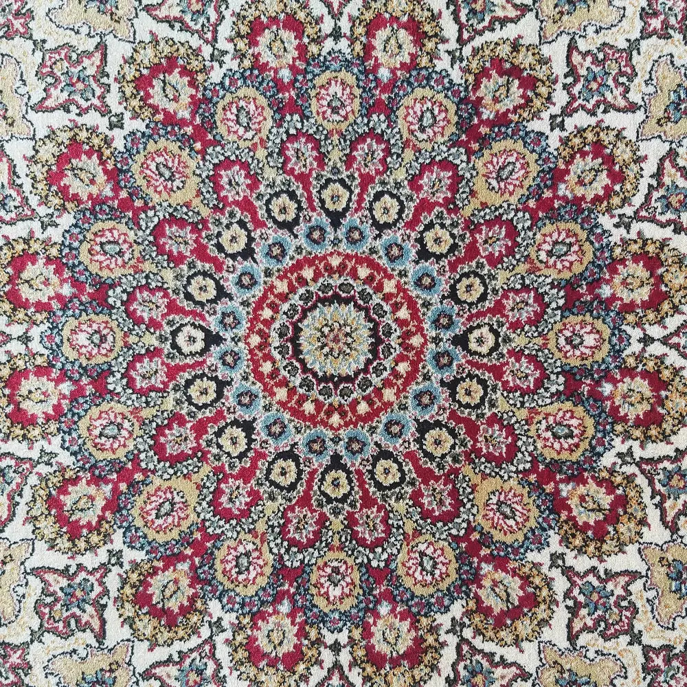Eksklusiv tepesamling Pers, nærbilde av rødt teppe med orientalsk mønster og sirkulært blomsterfelt i midten.