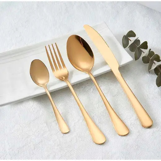 Fire deler matt gullbestikk på hvitt fat med grønne blader, sett ovenfra mot hvit bakgrunn.