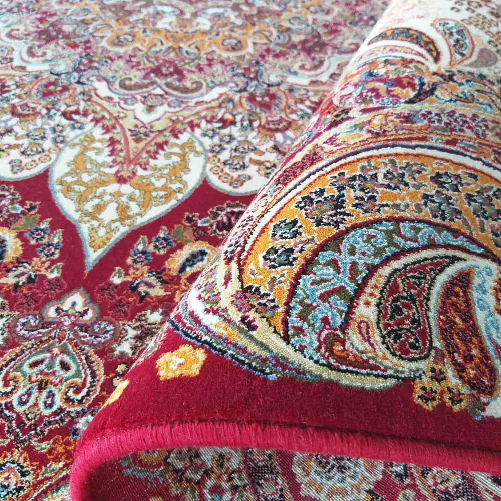 Eksklusivt Tepes Pers, detaljert nærbilde av rødt orientalsk teppe med synlig tykkelse og tekstur.