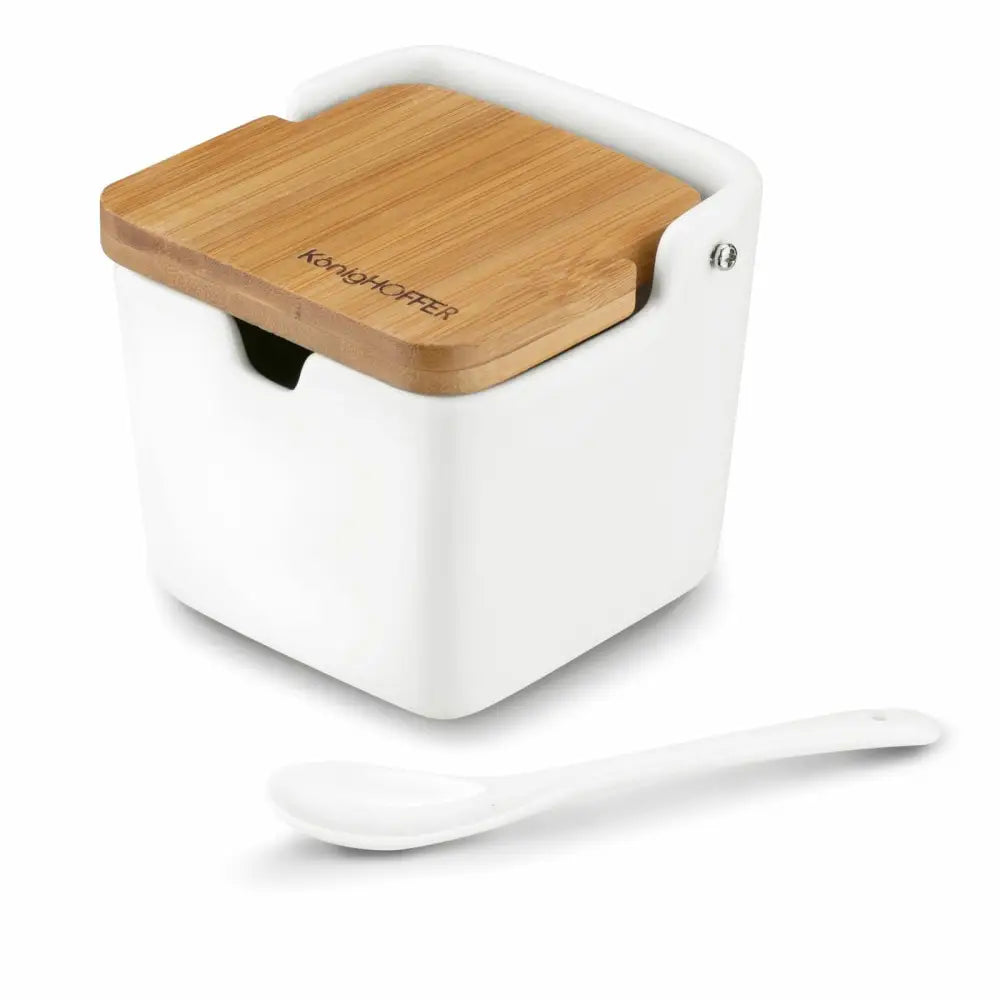 Elegant hvit porselens sukkerbolle med lyst bambuslokk, skråvisning med medfølgende hvit skje foran.