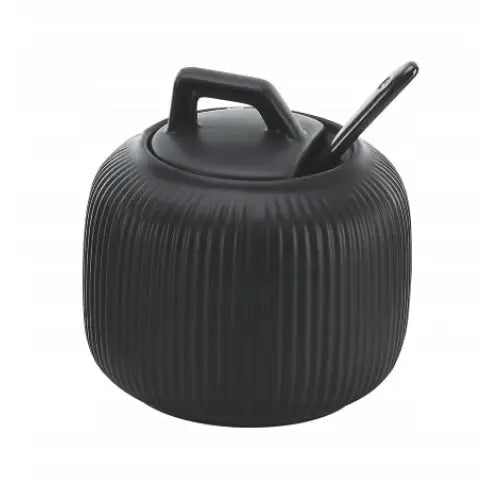 Elegant svart sukkerboks med matt finish, vertikale riller, lokk og tilhørende skje sett skrått forfra.