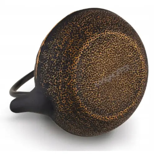 Tekanne i støpejern Hanako gull, underside med grov prikkete tekstur og synlig hank i brunsvarte nyanser.