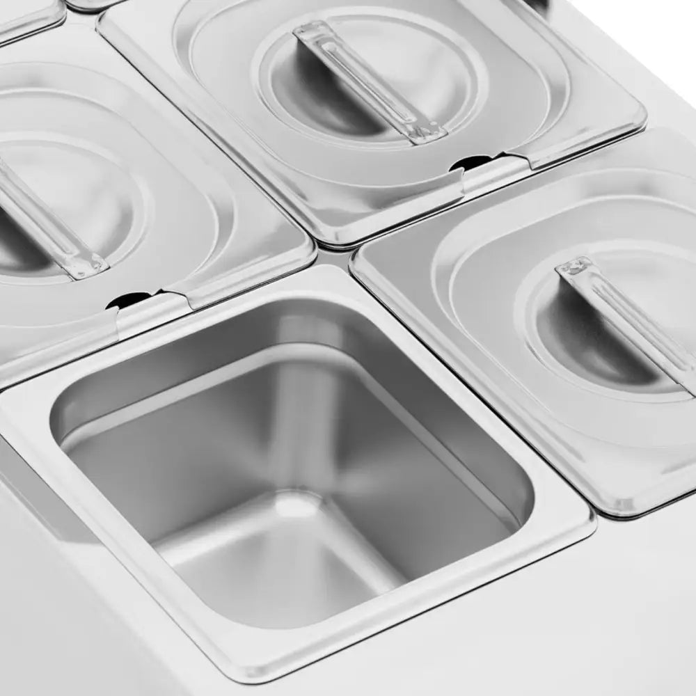 Elektrisk sjokolade- og sausoppvarmer med fire rektangulære stålkammer, én åpen som viser innsiden.