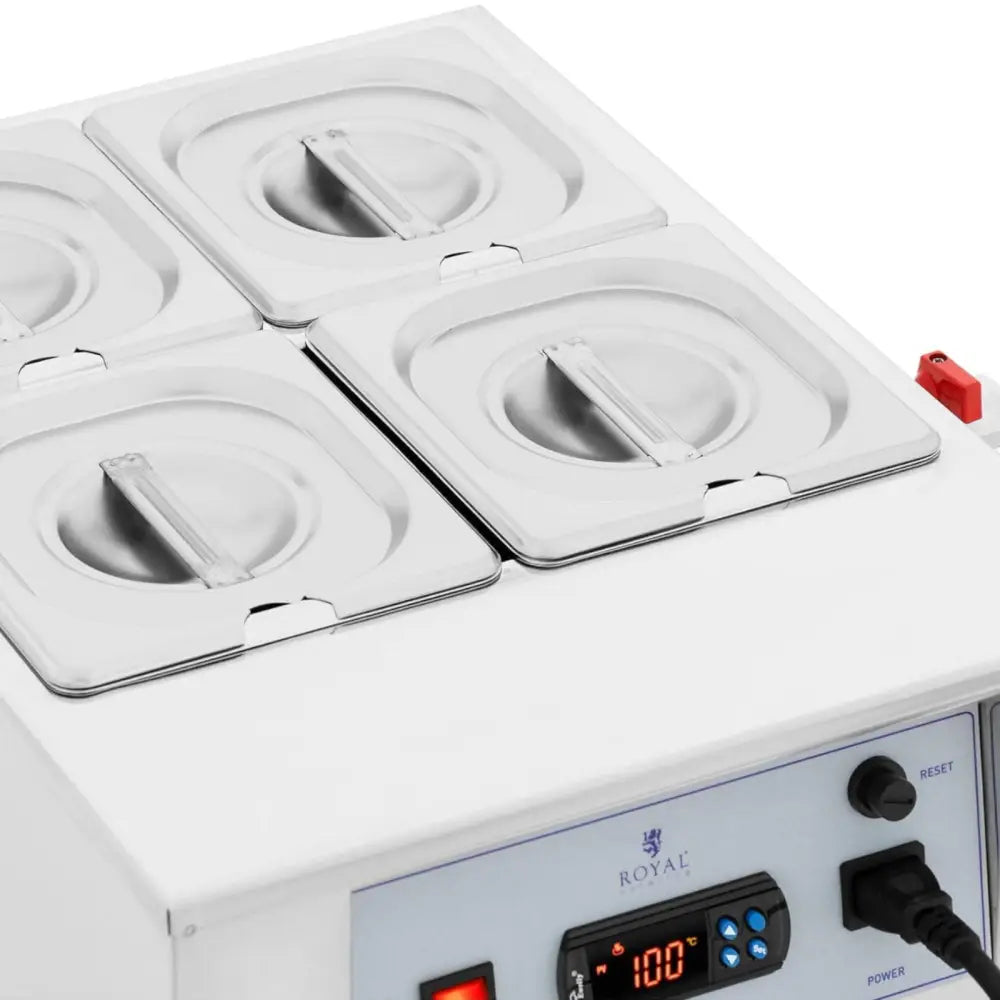 Elektrisk kokesjokolade fondue med fire firkantede beholdere, stållokk og synlig digitalt kontrollpanel.