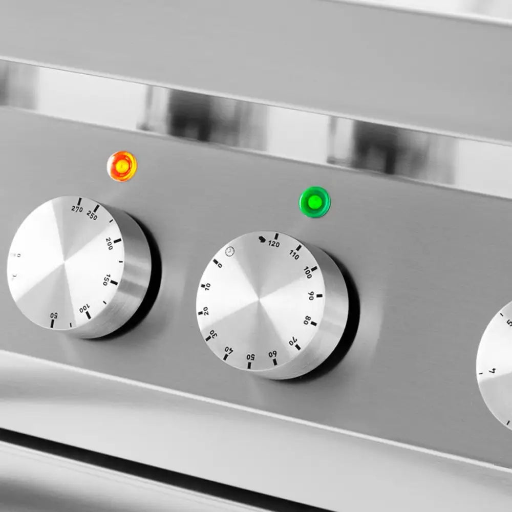 Elektrisk 6-brenners komfyr, nærbilde av to dreieknapper og indikatorlamper på rustfritt panel.