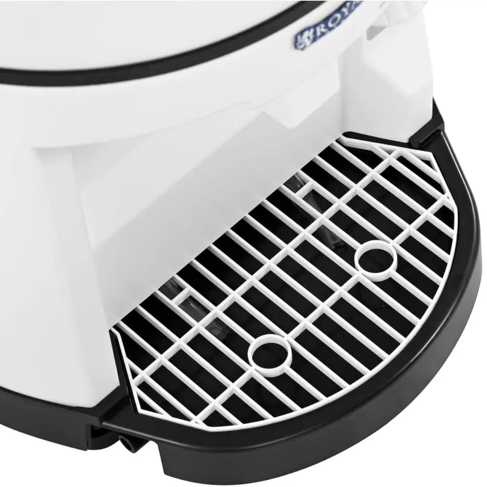 Elektrisk isknuser, detalj av hvit og svart plastdryppbrett med gitter og to runde utsparinger, sett skrått nedenfra.