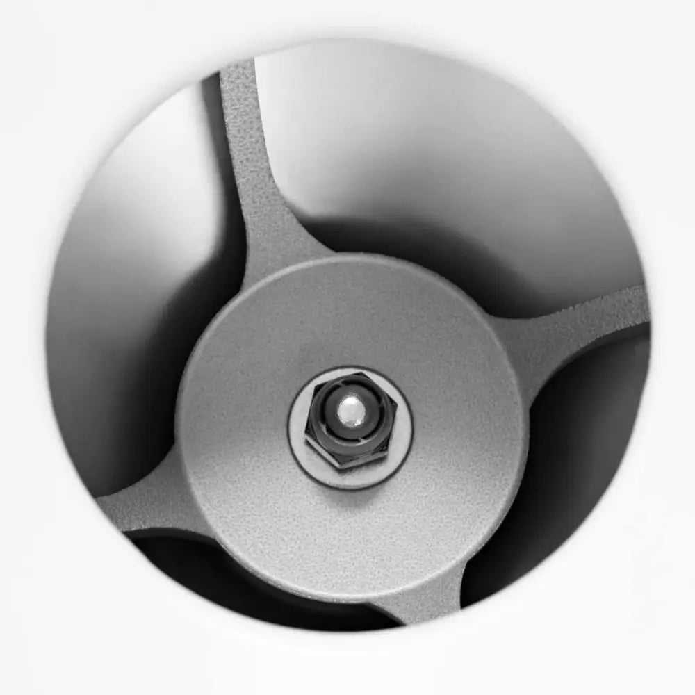 Elektrisk isknuser, nærbilde av tre metalliske knivblader og sentral festemutter sett ovenfra.