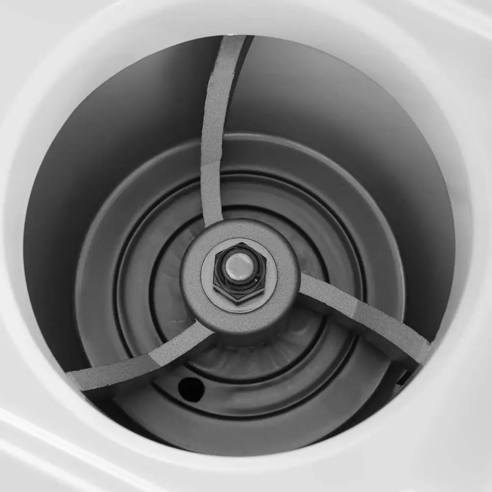 Elektrisk iskvern, nærbilde av metallisk innmat med tre grå armer og sentral bolt i sirkulær beholder.